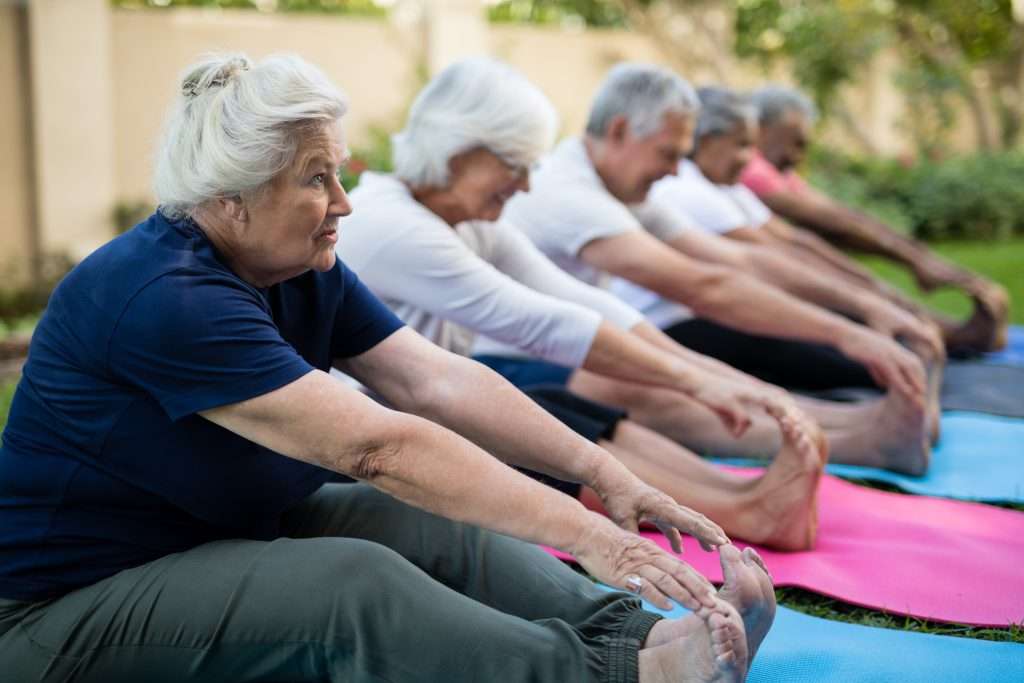 Senior female exercising with friends